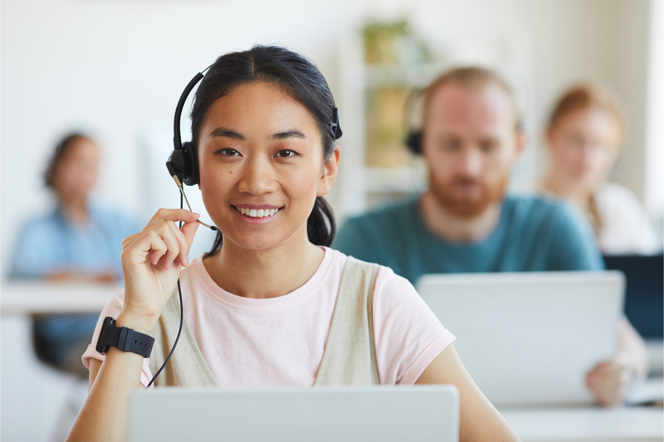 photo of a woman in front of her PC smiling and holding a mic